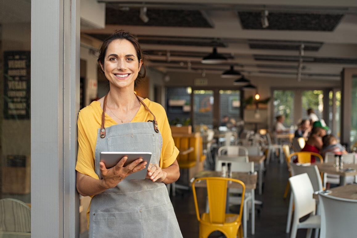 Small business owner working on tablet in her restaurant.