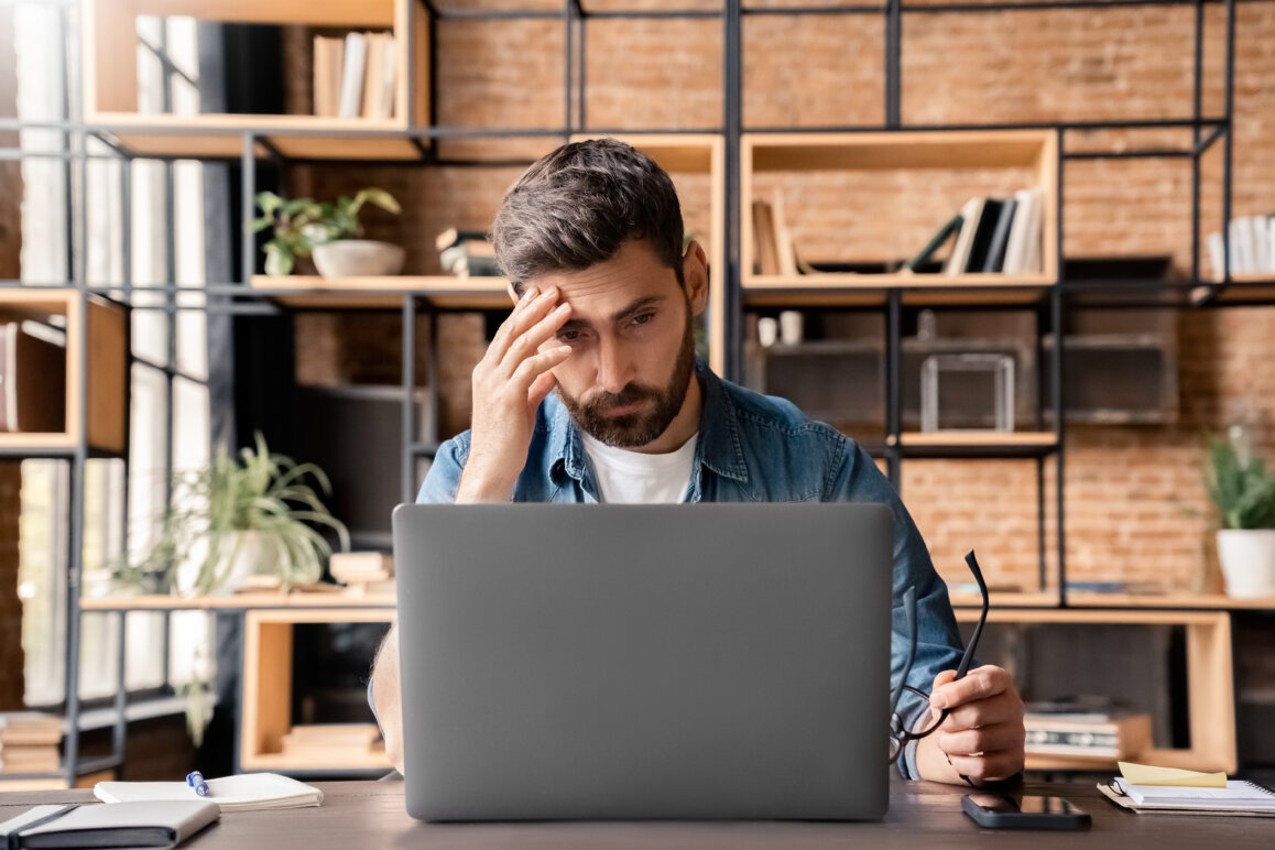 Man in deep concentration while working on a laptop.