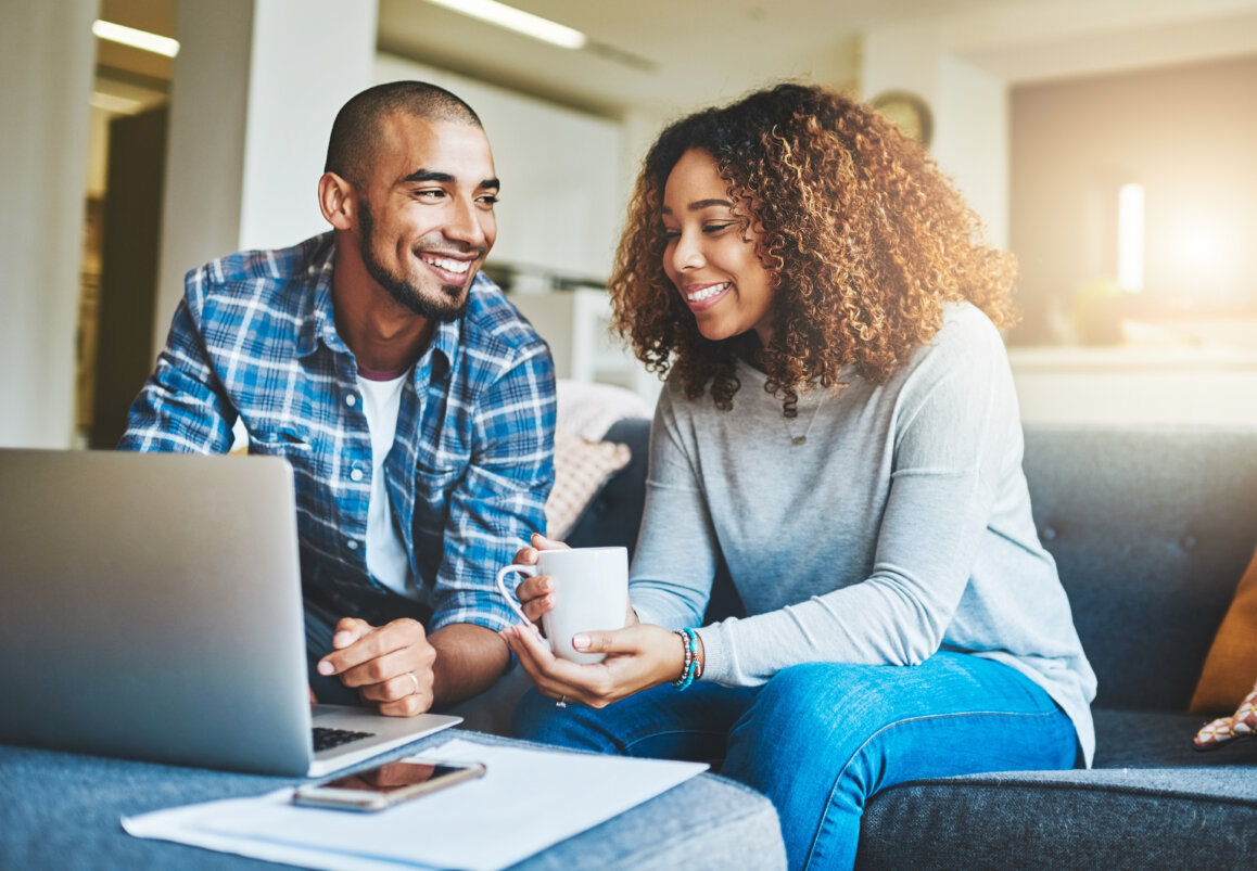 Young couple managing finances on laptop.