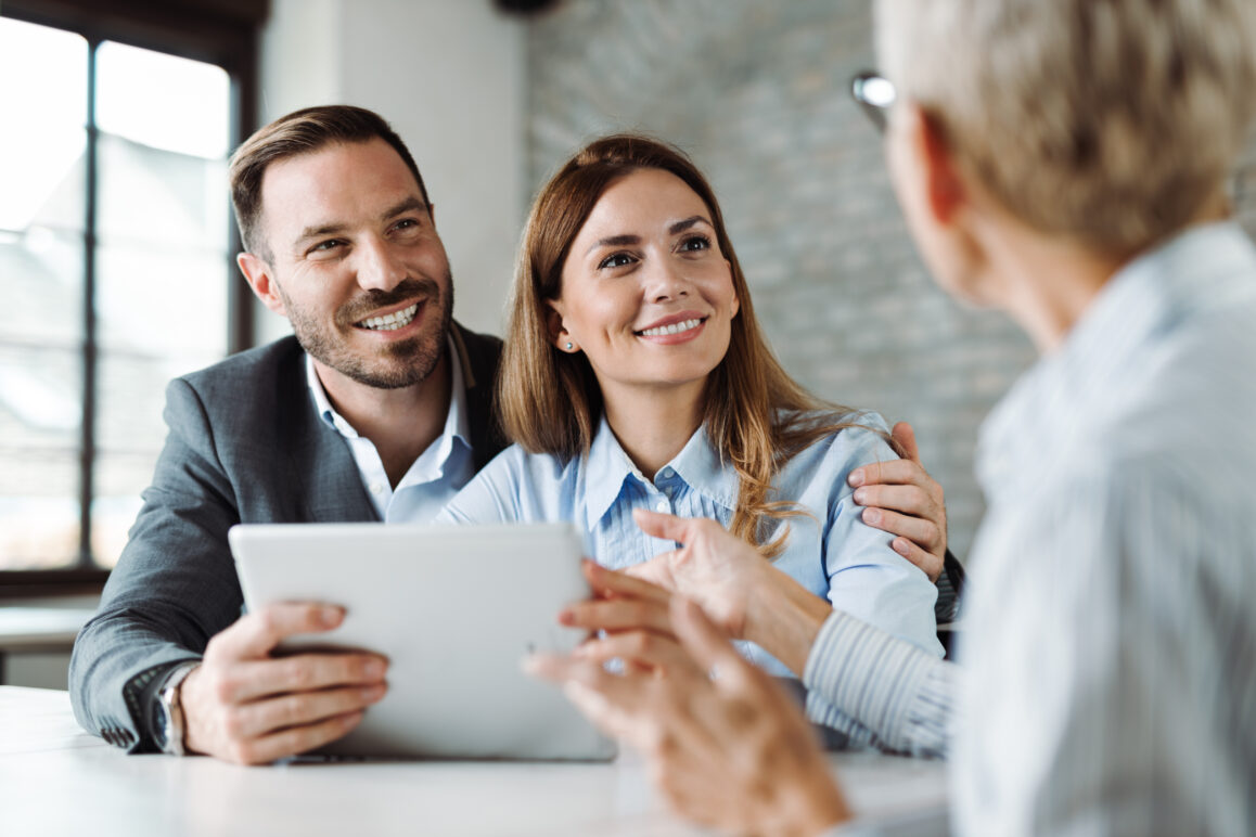 Happy couple talking with insurance agent on a meeting